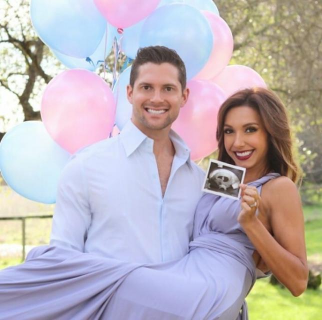 Hughes holds his wife in his arms with a picture of their baby.