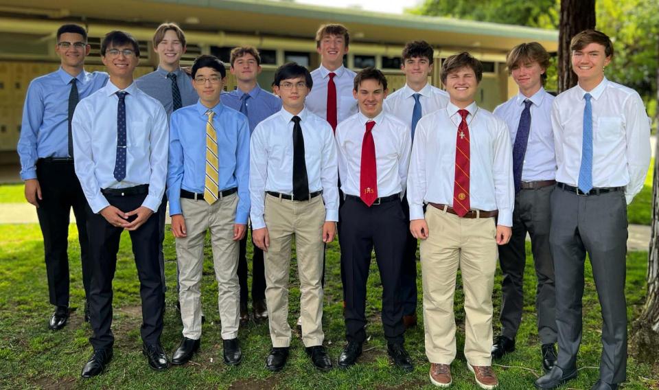 Group of seniors standing in formal attire on quad