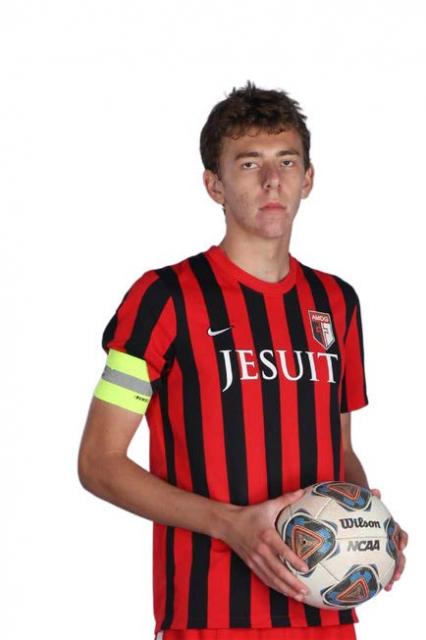 Strangio in uniform, holding a soccer ball and wearing a captain's arm band