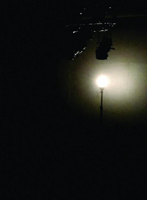Image of a small, single light on a dark stage/room.