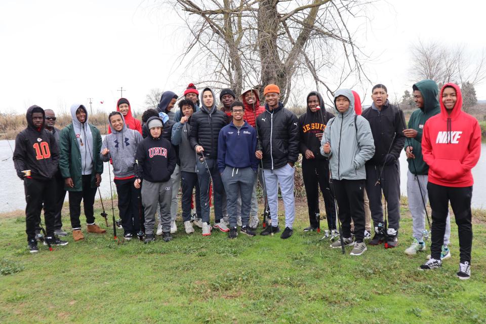 Group photo of BSU students standing by water on a winter day.