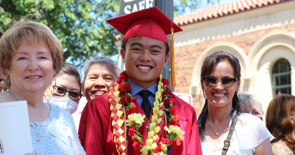 Castaneda smiling on steps of Memorial Auditorium after graduation ceremony