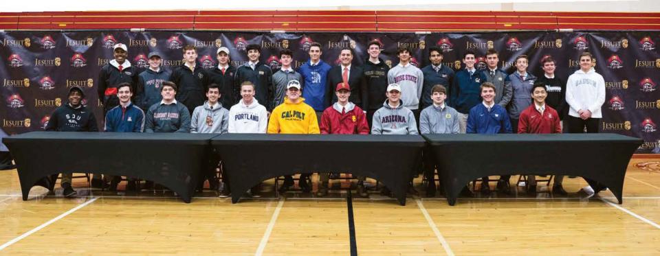 Student Athletes lined up behind a table in gym.