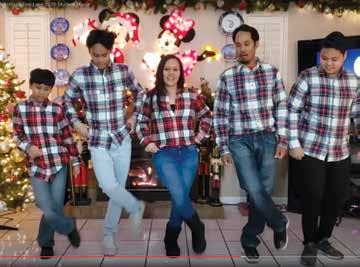 Family doing a line dance, wearing matching flannel.