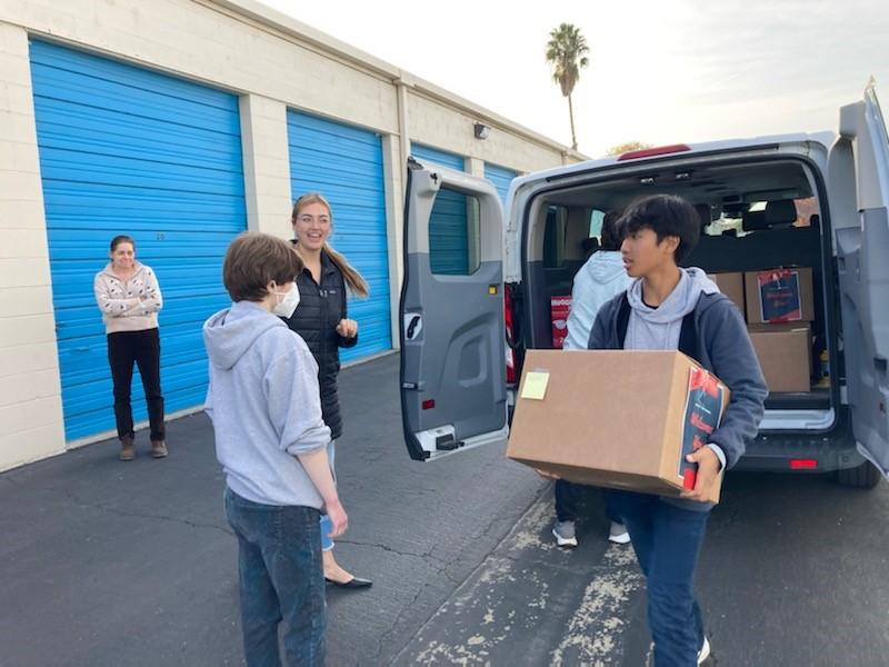 Student unloads a box from van at a storage unit