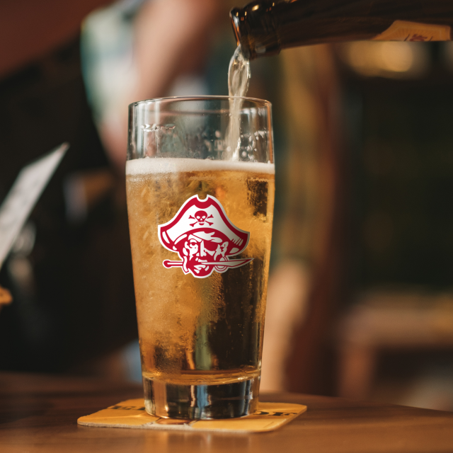 Image of a filling pint glass with Jesuit mascot on glass.