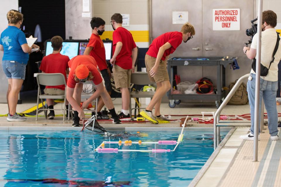 Robotics team by the pool during a competition