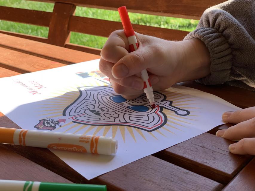 Closeup of youth hand with marker solving a maze.