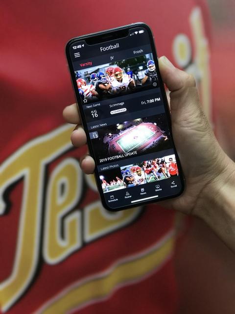 hand holding a mobile phone with athletics app open