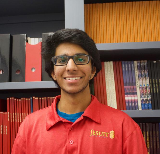 Jaiveer standing in front of past student publications