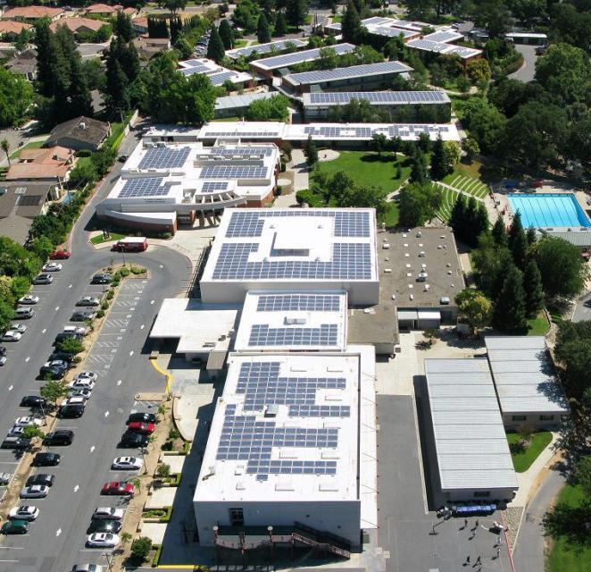 Arial photo showing the solar panels on top of the school buildings.