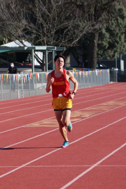 Lone runner in Jesuit uniform running on track