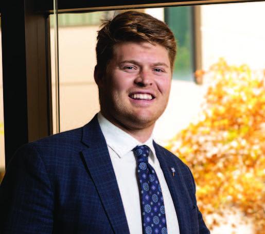 Law in suit smiling by a window