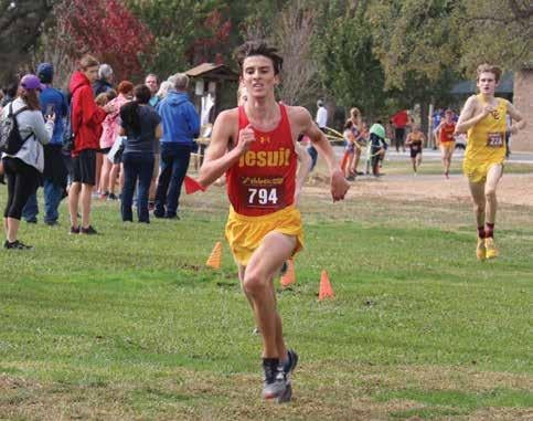 Pickren running across a field with fans in the background cheering.