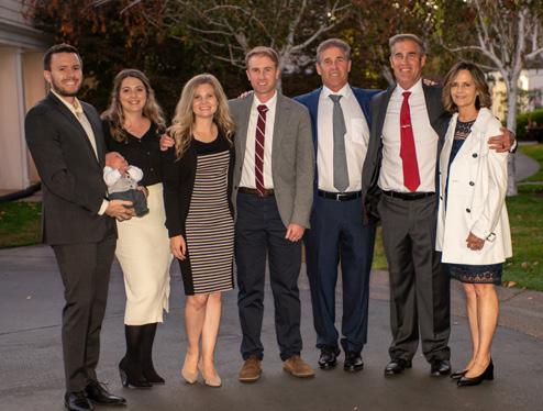 A group of adults in formal attire standing outside