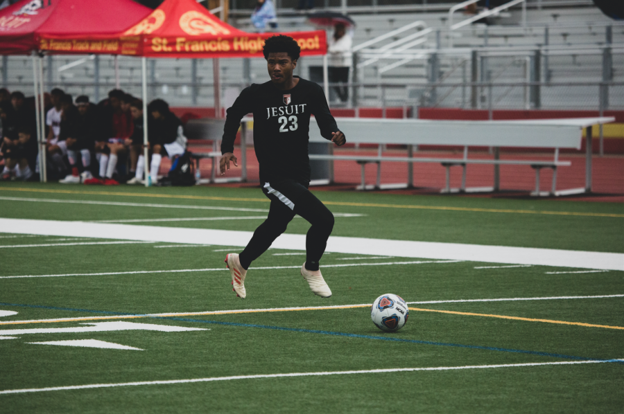 Jesuit striker Elijah Beverly '21 dribbling the soccer ball in a home game last season.