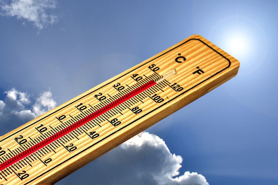 Image of thermometer over 90 degrees with sky and sun in the background