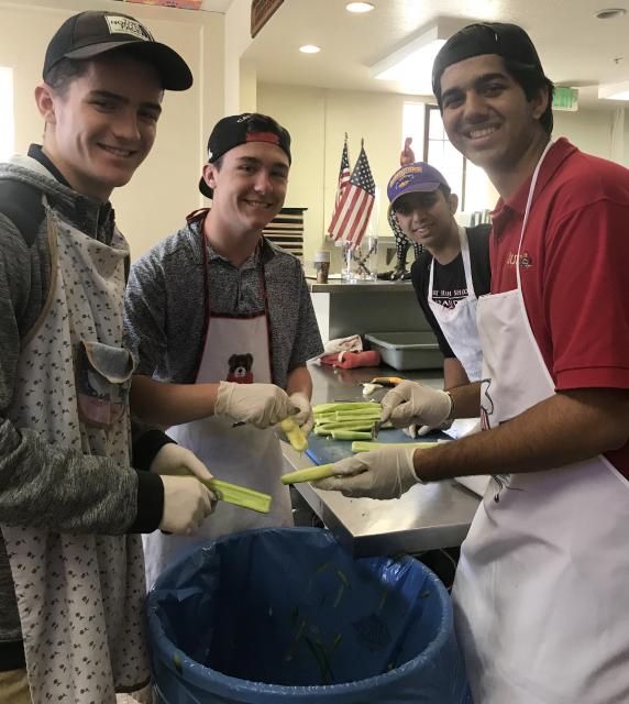 Four students prepping food in a kitchen