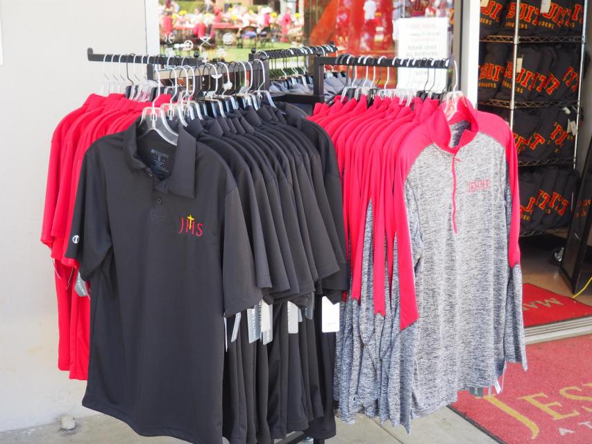 Clothing rack showing long and short sleeved shirts with Jesuit Logo