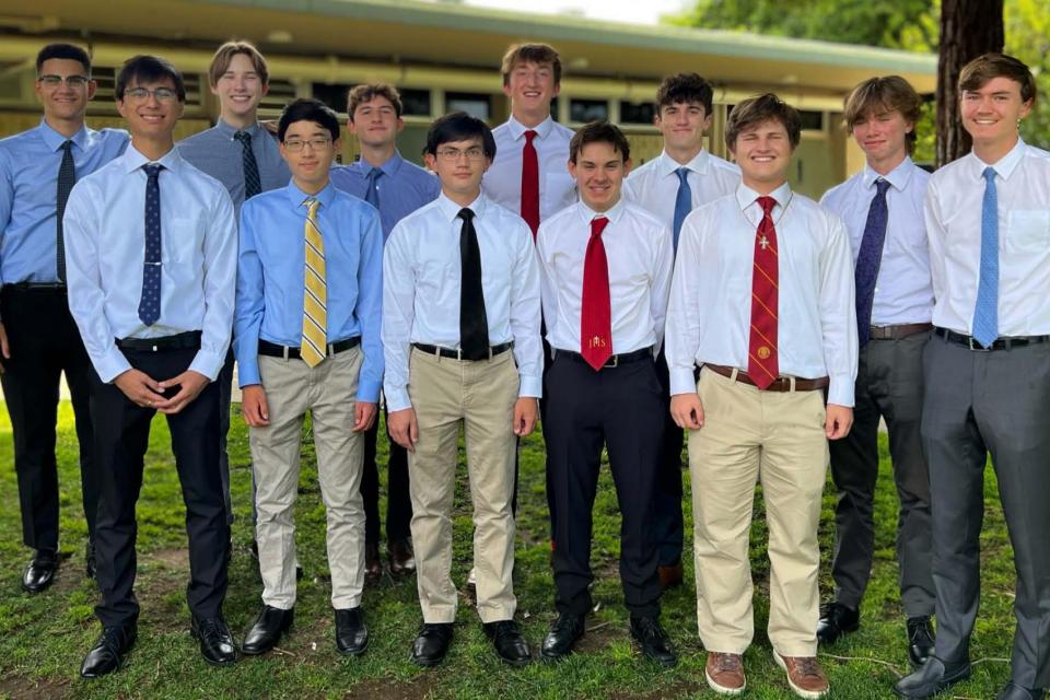 Group of seniors standing in formal attire on quad