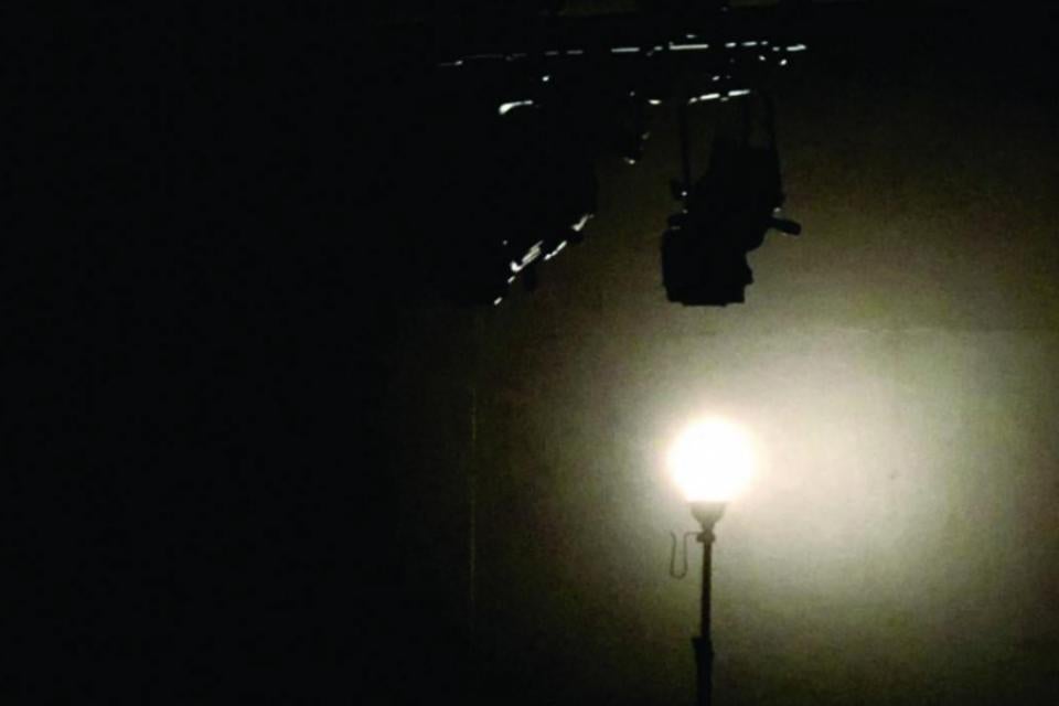 Image of a small, single light on a dark stage/room.