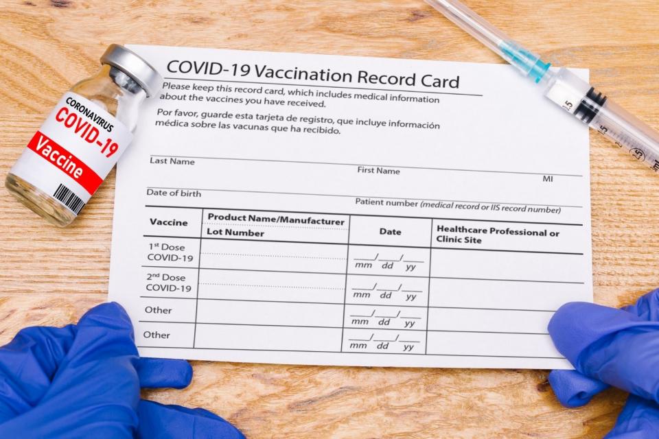 Image of empty COVID vaccine card and syringe