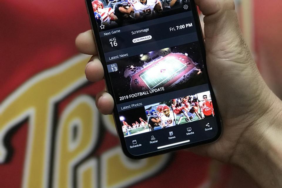 hand holding a mobile phone with athletics app open
