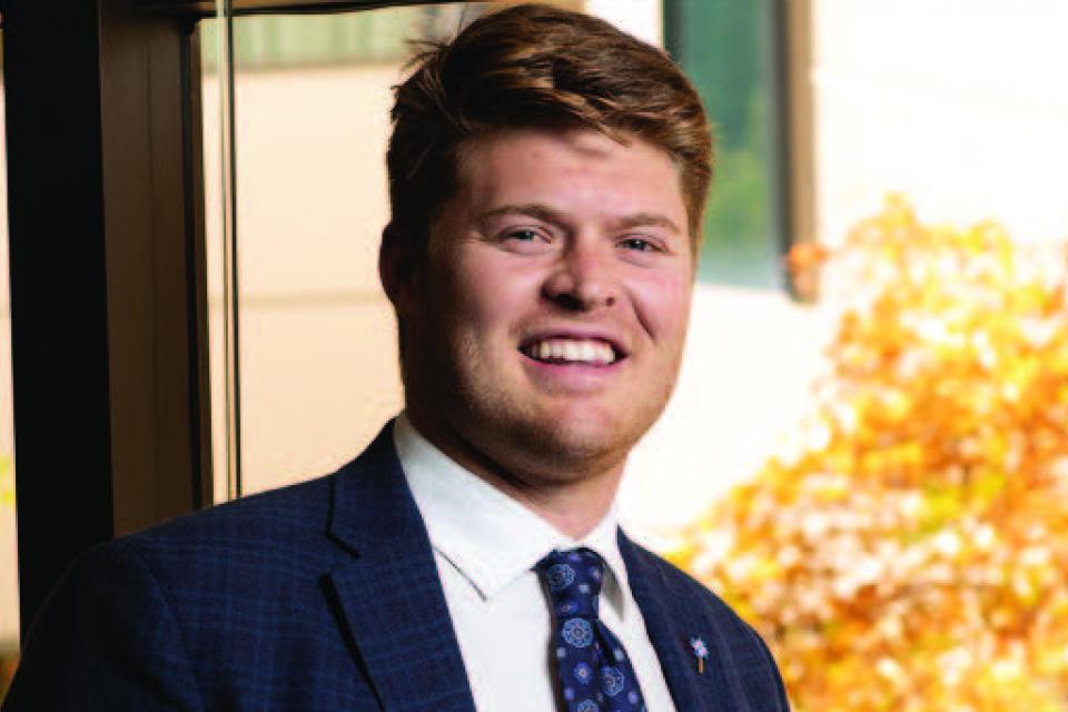 Law in suit smiling by a window