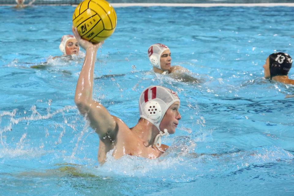 Jesuit water polo player rising to take a shot on goal