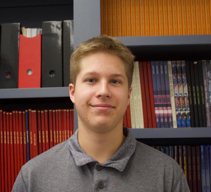 Davis standing in front of past student publications