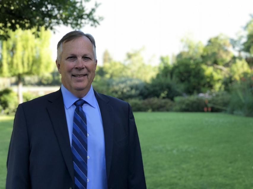 Image of James on campus in front of garden