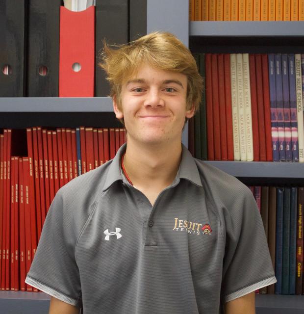 Gage standing in front of past student publications