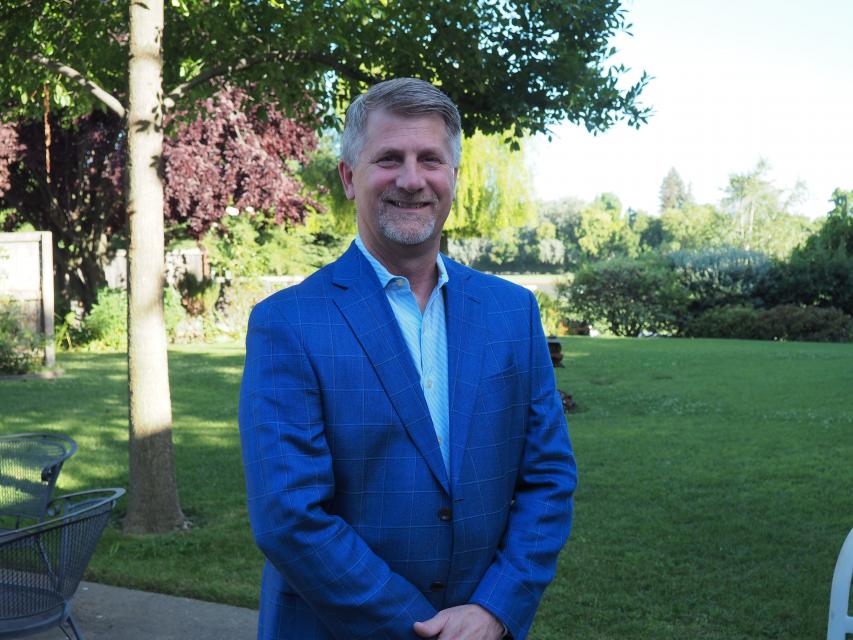 Image of Kevin on campus in front of garden