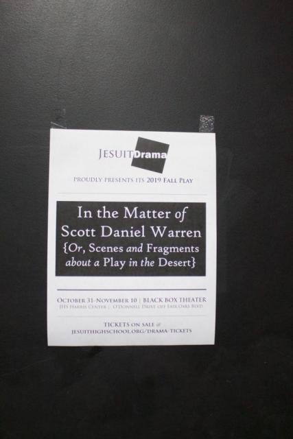A single black and white poster for Fall Play taped to a wall.