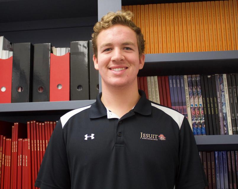 Jaryd standing in front of past student publications