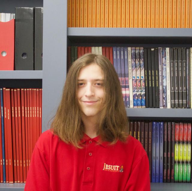 Jason standing in front of past student publications