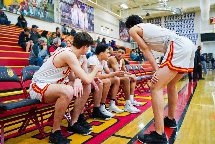 Isa Silva, right, instructing his teammates in a basketball game against Elk Grove High School in the Fr. Barry Gymnasium at Jesuit High School on Friday, Feb. 7, 2020.