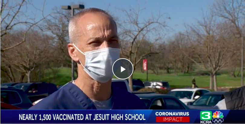 Still of interview of Dr. Rusty Oshita speaking in parking lot where vaccine clinic held 