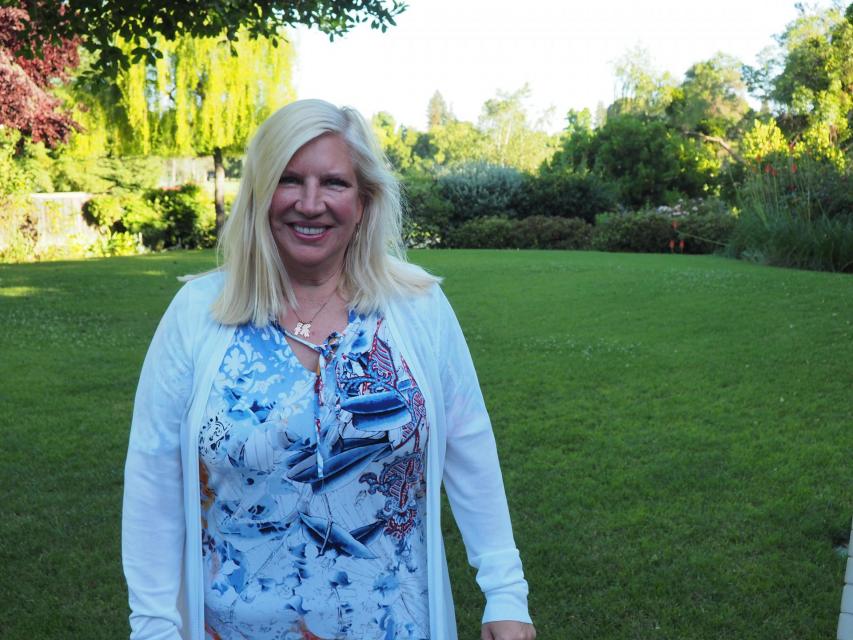 Image of Sandy on campus in front of garden