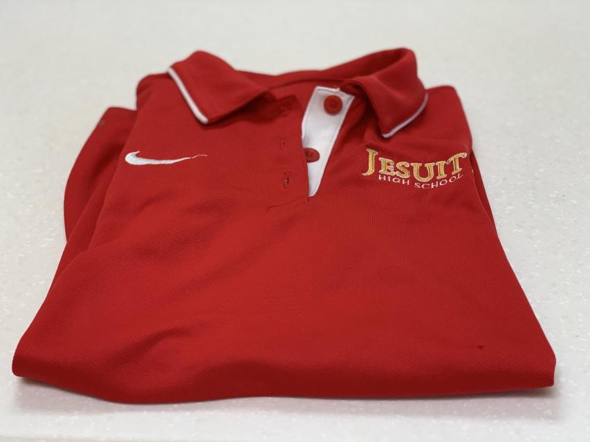 Image of a folded red JHS polo shirt