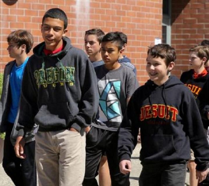 Group of young boys walking on campus and smiling.