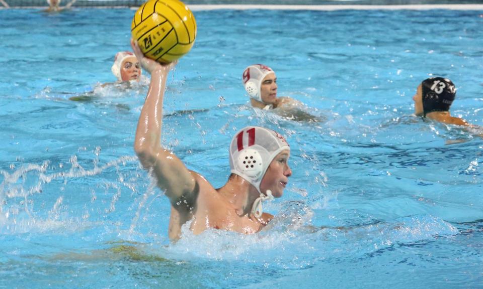 Jesuit water polo player rising to take a shot on goal
