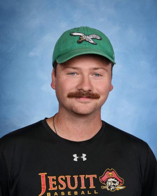 Head shot of Kyle Trivits in a Jesuit baseball shirt and green cap