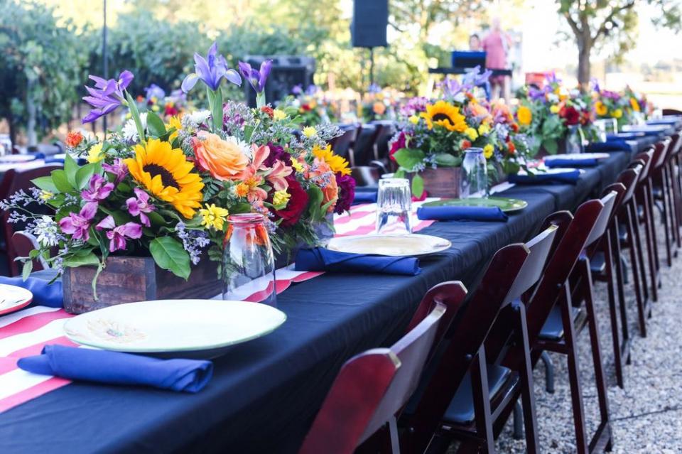 beautiful long table set outside with flowers