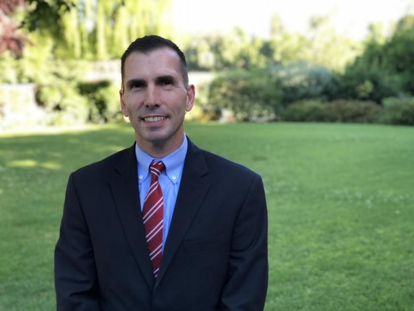 Image of Mitch on campus in front of garden